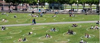 Em Düsseldorf, círculos marcados no gramado de um parque ajudam a manter o distanciamento entre as pessoas. 