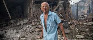 Morador de 71 anos de Soviansk observa a casa de seus parentes destruída  em ataque russo