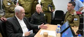 Gantz (sentado ao centro) juntou-se à coalizão de governo de Netanyahu (esq.) nos primeiros dias da ofensiva israelense contra Gaza