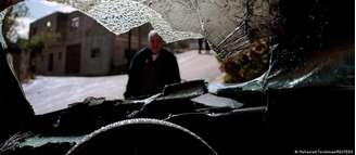 Homem observa carro que teria sido danificado por colonos israelenses na Cisjordânia (imagem meramente ilustrativa)