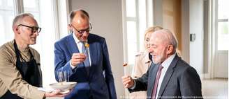 Lula provando salsichas em ambiente "gourmet" com Merz. Aparentemente não era o que o brasileiro queria