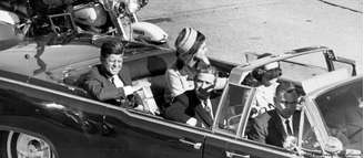 O presidente John F. Kennedy desfilando em carro aberto momentos antes do atentado que o mataria, em 1963