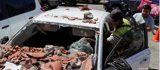 Carro danificado por escombros após terremoto