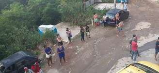 Filas com distanciamento físico são organizadas para distribuição de cestas básicas e roupas na Estradinha, no Rio