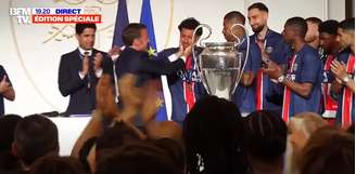 O presidente da França, Emmanuel Macron, faz carinho no rosto do brasileiro Marquinhos, capitão do PSG