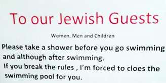 O texto do cartaz em inglês, diz:
"Para nossos convidados judeus
Mulheres, homens e crianças

Por favor, tome banho antes de ir nadar e, embora depois de nadar.
Se você infringir as regras, eu sou forçado a cloar a piscina para você."