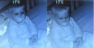 Bebê encara a câmera de babá eletrônica antes de dormir