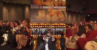 Fernanda Abreu diante do Cinéma L'Arlequin e a plateia aplaudindo o documentário