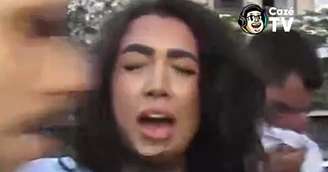 Aline Gomes no momento em que o homem surge, bate no microfone e a assusta