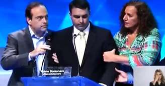 Jandira ajuda Flávio Bolsonaro, que teve um mal-estar durante o debate para a Prefeitura do Rio de Janeiro em 2016.