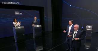 Um dos momentos tensos do debate na Band: os mediadores Adriana Araújo e Eduardo Oinegue precisaram erguer a voz para Flávio Bolsonaro (PL), Lula (PT) e a plateia no estúdio