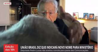 Fernando Gabeira tentando segurar sua gata pouco antes de ela tirá-lo do ar ao vivo