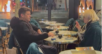 Casal toma drink perto de lixeira em chamas durante protestos em Paris