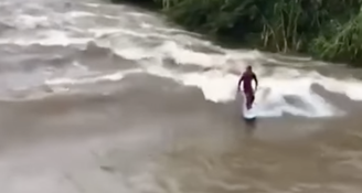 Homem surfa em rio de Praia Grande, em Santa Catarina, após ciclone atingir estado/