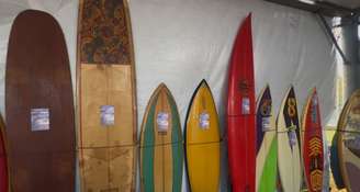 Colecionador expõe história do surfe em pranchas durante a 3ª etapa do Circuito Banco do Brasil de Surfe 2025 na Praia da Vila, em Imbituba (SC)