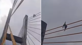 Home com bandeira do Brasil escala ponte em Impetriz (MA)