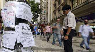 Homem lê anúncios de emprego no centro de São Paulo em março