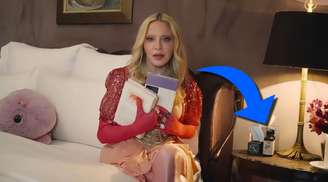 Madonna em sua cama e, na mesa, o frasco do óleo usado contra dores pelo corpo