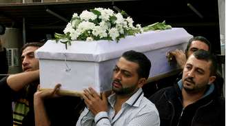 Homens carregam caixão de criança morta em ataque de morteiro a bairro de Damasco, no dia 12 de novembro