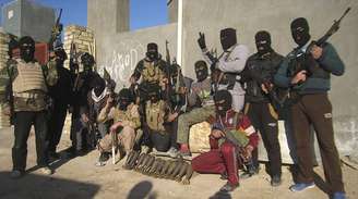 <p>Muçulmanos sunitas tiram foto mostrando armas na cidade de Falluja, escalada da violência no país matou nove mil pessoas em 2013</p>
