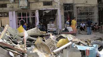 <p>Moradores olham para o local de um dos ataques com carro-bomba em Bagdá, em 14 de julho</p>