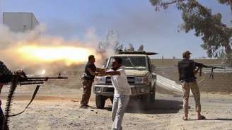 <p>Combatentes da brigada islâmica Misarata atiram contra o aeroporto de Trípoli na tentativa de tomar o controle da região, dominada por uma poderosa milícia rival, em 26 de julho</p>
