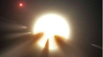 Ilustração mostra uma estrela atrás de um cometa fragmentado; observações sugerem que esse seja o motivo dos misteriosos padrões de luz da estrela KIC 8462852