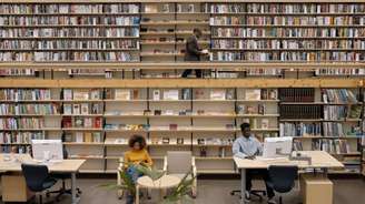 Imagem mostra uma biblioteca e pessoas negras lendo e trabalhando.