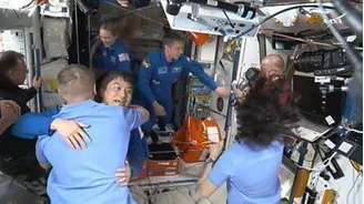 Astronautas se abraçam após chegada da tripulação a borda da Space X na estação espacial