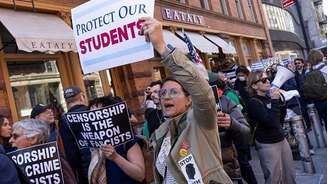 Em protesto contra medidas de Trump, mulher segura cartaz com os dizeres 'Proteja Nossos Estudantes'