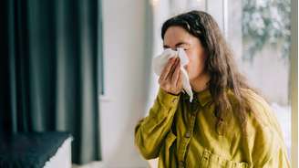 Mulher assoando o nariz