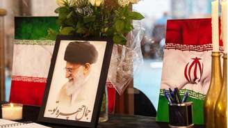 Retrato do líder supremo do Irã, o aiatolá Ali Khamenei, é exibido ao lado de bandeiras iranianas, velas e um livro de condolências em uma mesquita na Cidade do Cabo