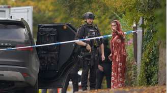 Policial armado conversa com morador perto de sinagoga atacada a faca em Crumpsall, em Manchester, em 2 de outubro de 2025.