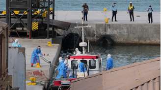 Profissionais de saúde usando equipamentos de proteção evacuam pacientes do cruzeiro MV Hondius no porto de Praia, em Cabo Verde, na quarta-feira, 6 de maio de 2026.
