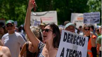 Manifestante segura placa com os dizeres em espanhol: "Direito à moradia" durante uma manifestação realizada em Madri, Espanha, em 24 de maio.