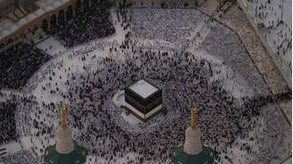 Peregrinos vestidos de branco realizam o rito do “tawaf”, que consiste em dar voltas ao redor da Caaba — a estrutura cúbica negra para a qual os muçulmanos de todo o mundo se voltam para rezar — no coração da Grande Mesquita.