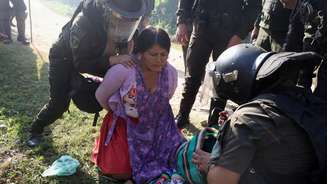Policiais revistam uma manifestante enquanto retiram membros da comunidade que ocuparam a instalação petrolífera Humberto Suárez, em Santa Rosa del Sara, para exigir a renúncia do presidente Rodrigo Paz. Os protestos em curso causaram escassez de combustível e alimentos na Bolívia. (03/06/2026)