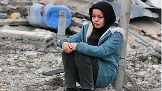 Uma menina entre as ruínas de edifícios em Gaza