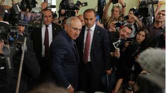 O primeiro-ministro armênio, Nikol Pashinyan, ao centro, olha para os fotógrafos após votar em uma seção eleitoral durante as eleições parlamentares em Ierevan, Armênia, em 7 de junho de 2026.