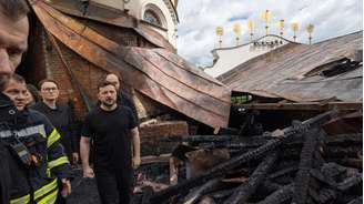O presidente da Ucrânia, Volodymyr Zelensky, entra na catedral da Dormição do mosteiro Kiev-Petchersk Lavra, ao lado da primeira-ministra Yulia Svyrydenko (à esq.) e do ministro do Interior, Ihor Klymenko, após o edifício ser danificado em um ataque de drone durante a madrugada, em Kiev, nesta segunda.
