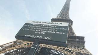 Torre Eiffel com um cartaz gigante anunciando seu fechamento antecipado devido à onda de calor em Paris, em 23 de junho de 2026.
