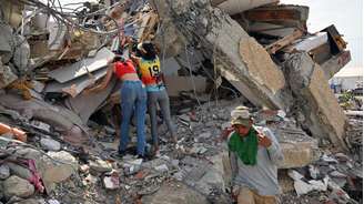 Moradores trabalham com as próprias mãos para tentar salvar sobreviventes.