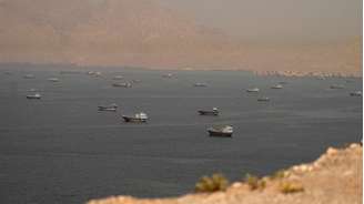Dezenas de embarcações cruzam o Estreito de Ormuz, cercado por montanhas rochosas, visto da península de Musandam, em Omã.
