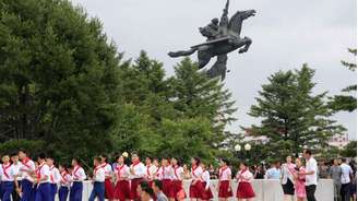 Estudantes seguem em direção às estátuas de Kim Il Sung e Kim Jong Il na colina Mansu para homenagear o fundador do regime norte-coreano no 32º aniversário de sua morte, em 8 de julho. A data é uma das mais importantes do calendário político do país.