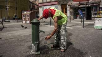 Homem enche uma garrafa de água durante uma onda de calor, em 22 de junho de 2026. O país enfrenta sucessivos episódios de temperaturas extremas e ampliou medidas de proteção para a população mais vulnerável.