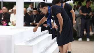 Mulheres acendem 86 velas em memória das vítimas durante cerimônia inter-religiosa em Nice, em 13 de julho de 2026.