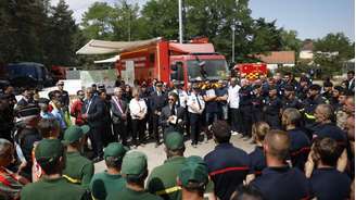 O presidente francês, Emmanuel Macron, conversa com bombeiros e agentes de segurança durante visita ao centro de comando das operações contra o incêndio na floresta de Fontainebleau, nos arredores de Paris.