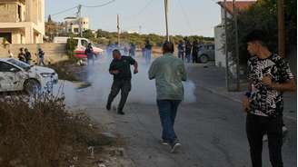 Soldados israelenses lançam granadas de gás lacrimogêneo contra palestinos na vila de Sarra, nas proximidades de Nablus, na Cisjordânia ocupada, em 25 de julho de 2026.