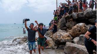 Migrantes atravessam a fronteira entre o Marrocos e o enclave espanhol de Ceuta durante a onda de entradas irregulares registrada no norte da África, em 30 de julho de 2026