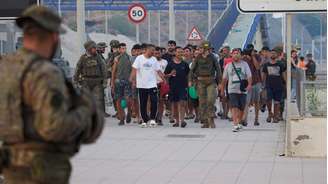 Escoltados pelo exército espanhol, os migrantes que cruzaram para a Espanha retornam ao Marrocos a partir do enclave espanhol de Ceuta no sábado, 1º de agosto de 2026.